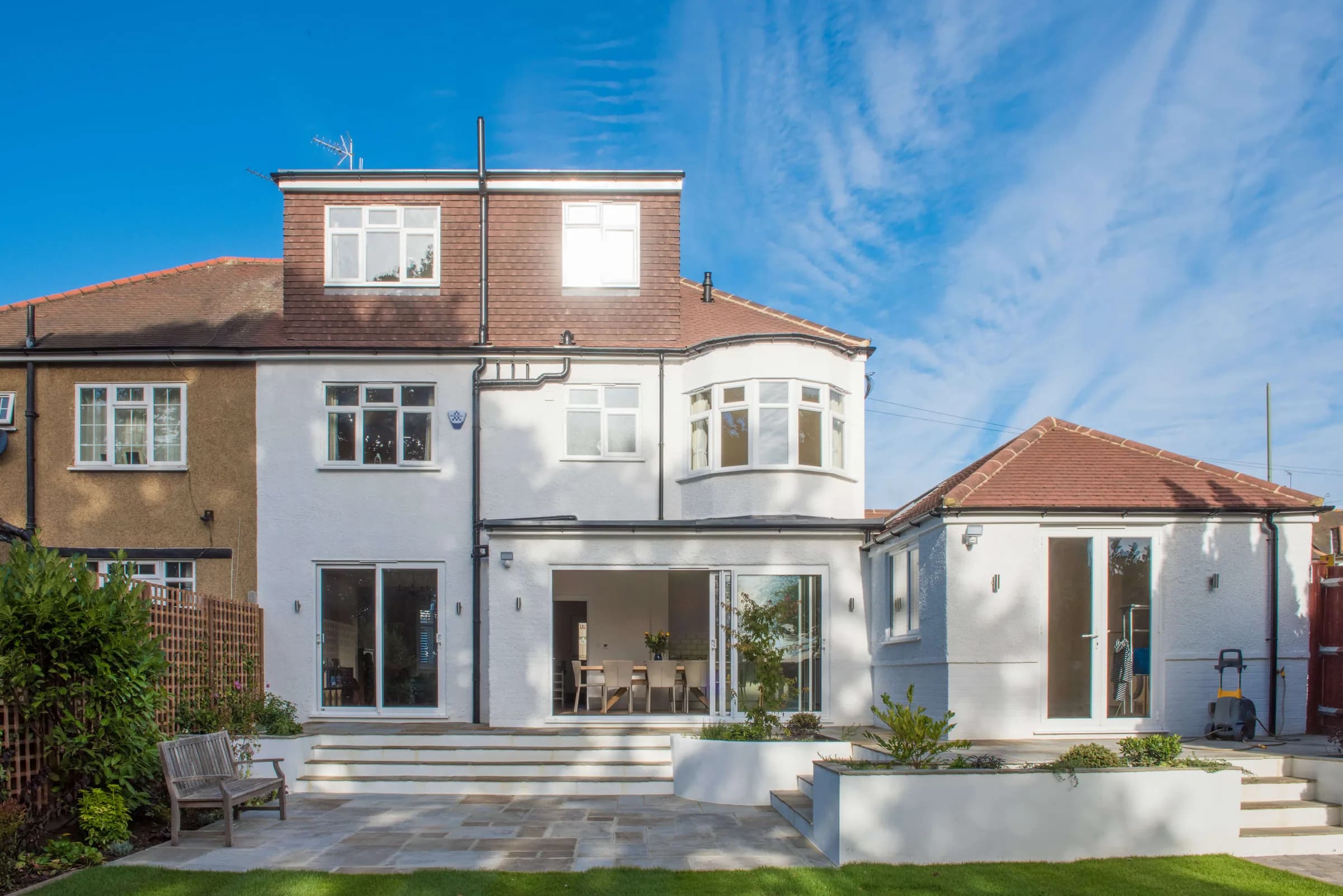 Landscaped garden with stone terrace, steps, planting and lawn